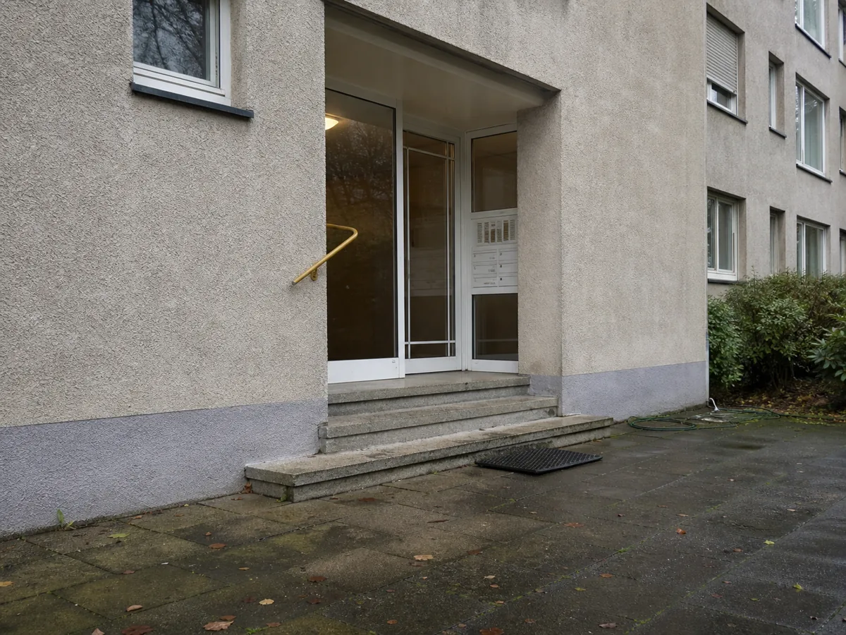 Eingangsbereich eines Mehrfamilienhauses mit Briefkastenanlage und Treppenstufen